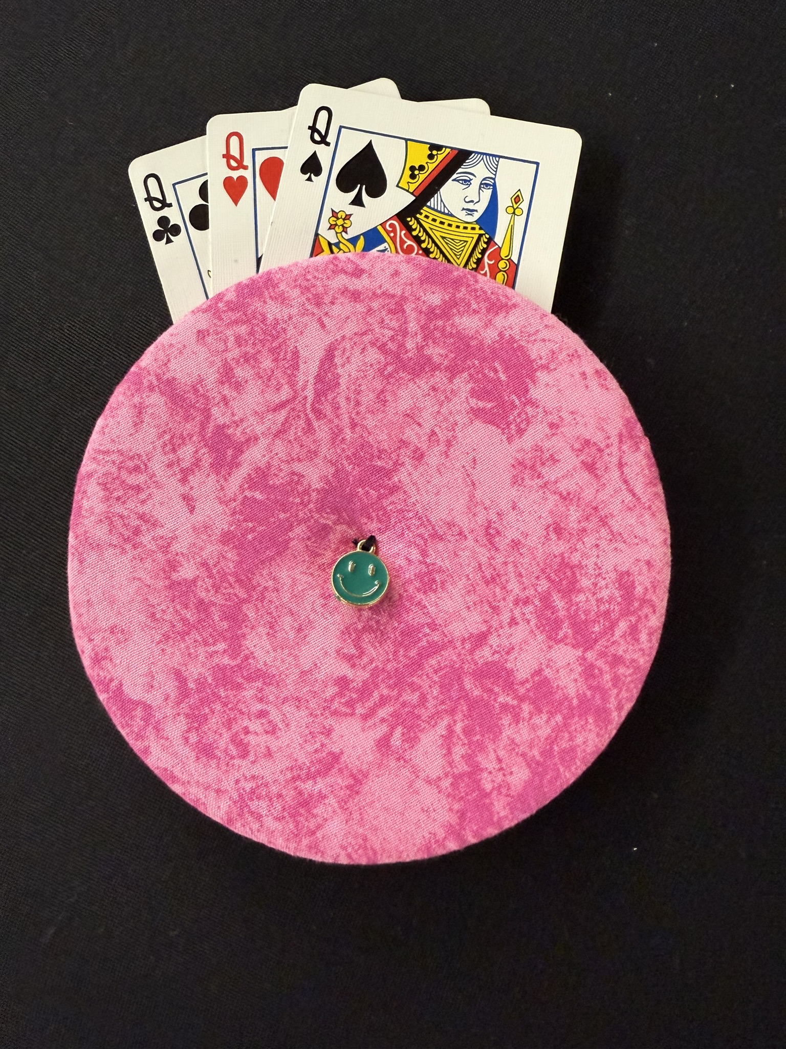 pink playing cards holder with green smiley face charm